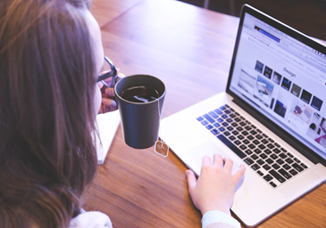 Woman at laptop drinking coffee