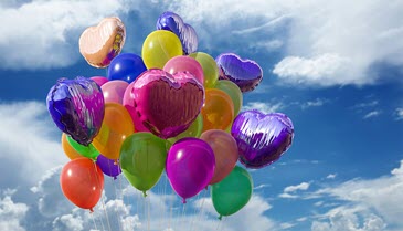 Floating balloons against sky.