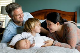 Family on bed with child.